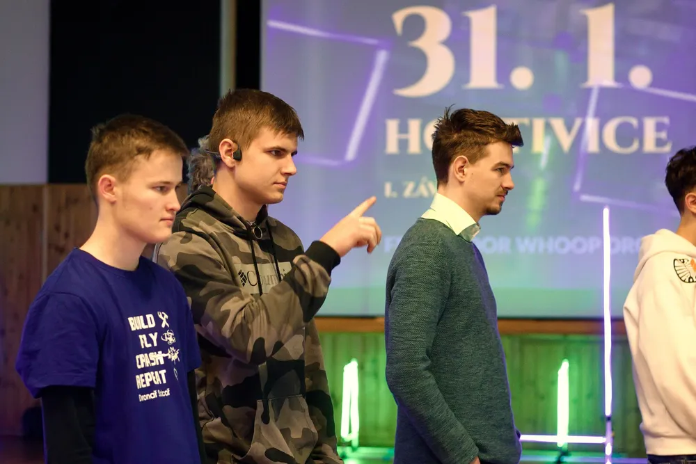 Piloti před plátnem s programem závodu